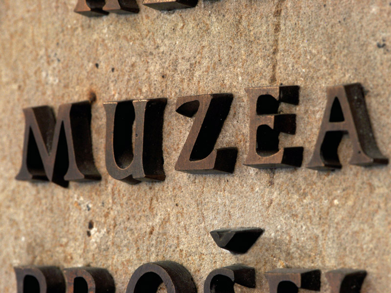Mosazná písmena na kamenné desce